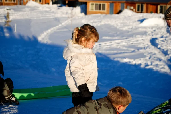 Hübsches kleines Mädchen in weißem Mantel im Schnee. — Stockfoto