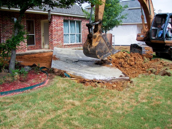 Backyard construction with tractor digging hole Royalty Free Stock Images