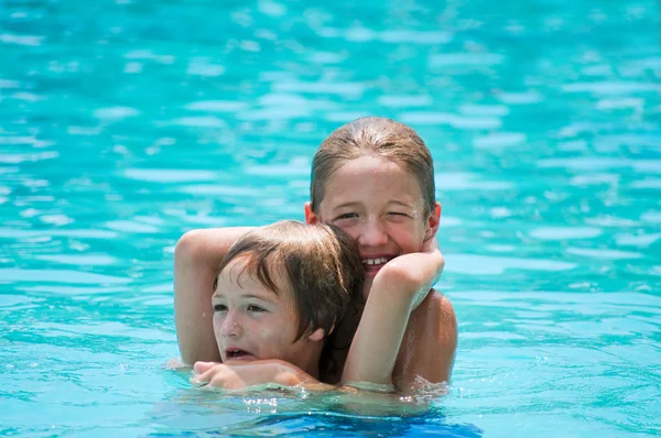 两个快乐的男孩在游泳池里摔跤. — 图库照片