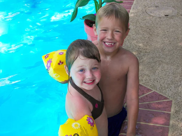 Happy boy and girl in swimming pool — Stock Photo, Image