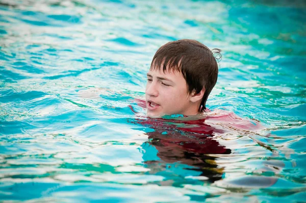 快乐的小男孩在游泳池里用的嘴唇噘起小. — 图库照片