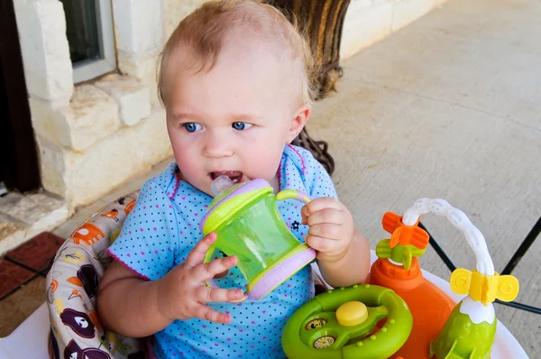 シッピー カップと外の青い目をした赤ちゃん女の子. — ストック写真