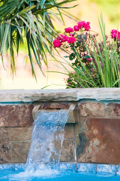 Lujosa piscina con cascada de piedra y rosas rosadas en b — Foto de Stock