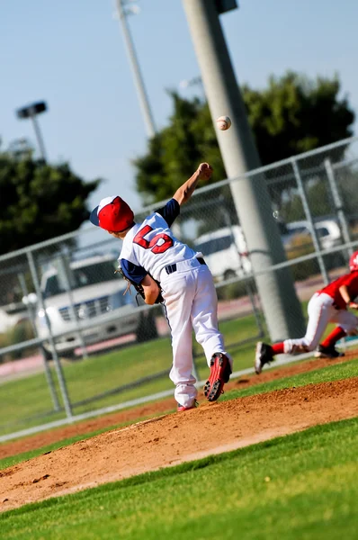 Little league pitcher kastar till första — Stockfoto