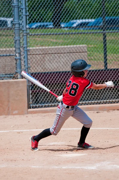 Amerikanischer Teenager-Baseballspieler schwingt den Schläger. — Stockfoto