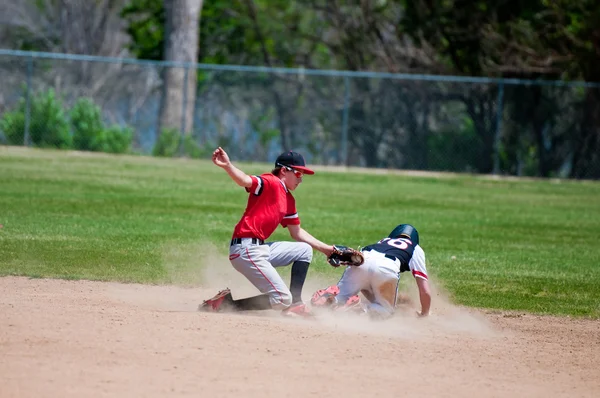 Dospívající shortstop tagování hráč baseballu, na druhé metě. — Stock fotografie