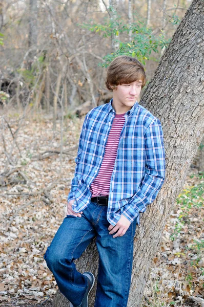 Handsome teen boy leaning on tree — Stock Photo, Image