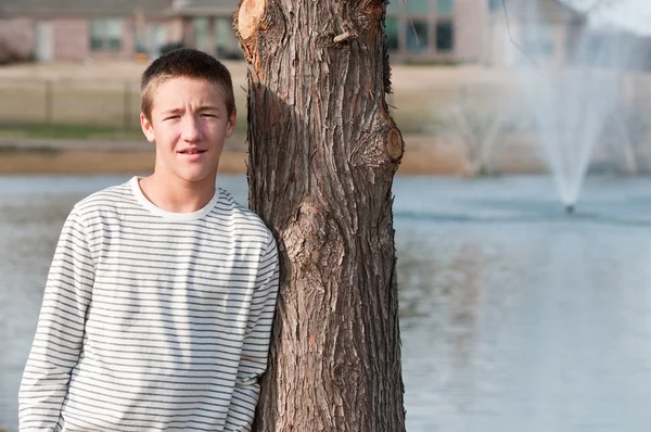 Préoccupé adolescent garçon penché sur arbre — Photo