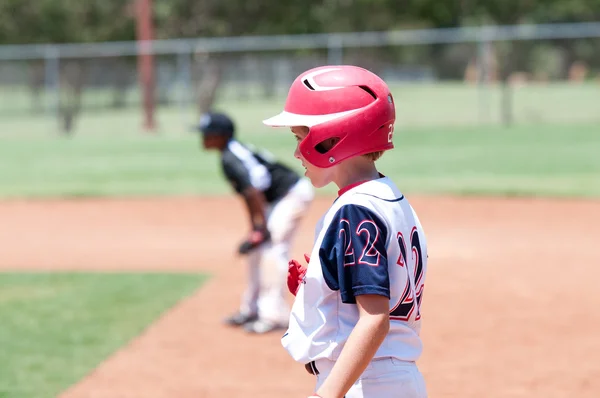 Joven chico de béisbol americano en primera base — Foto de Stock