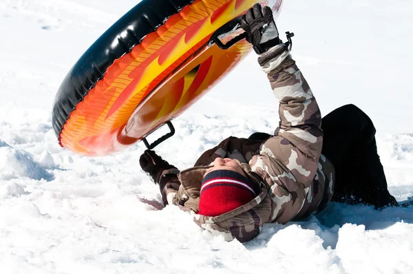 Young boy crashing on tube in the snow — Stock Photo, Image