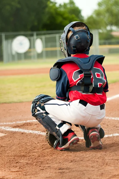 Jeune receveur de baseball derrière la base . — Photo