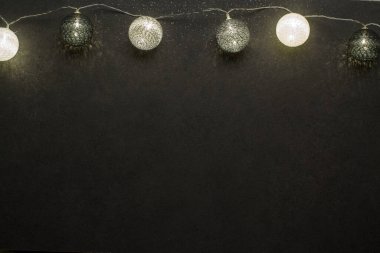 Koyu granit yüzeydeki ışıklar. Noel çelengi. Bir yazıt için yer.