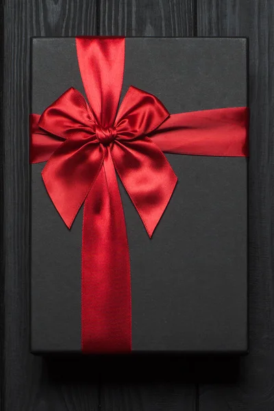 Μαύρο Κουτί Δώρου Κόκκινο Μεγάλο Φιόγκο Ξύλινη Επιφάνεια Φωτογραφία — Φωτογραφία Αρχείου
