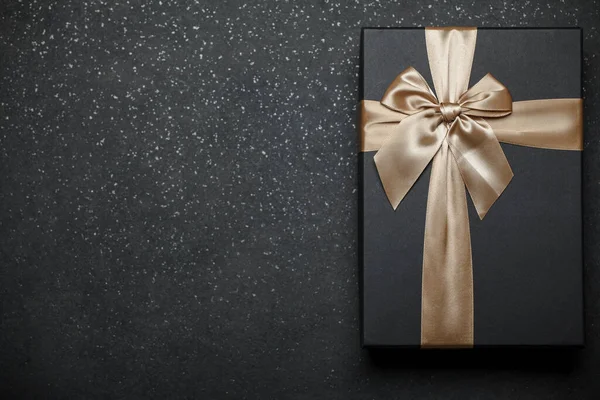 Schwarzer Geschenkkarton Mit Goldener Schleife Und Großer Schleife Auf Dunklem — Stockfoto