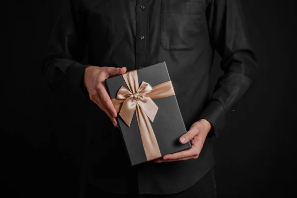 Tipo Con Una Camisa Negra Sostiene Regalo Con Una Cinta —  Fotos de Stock