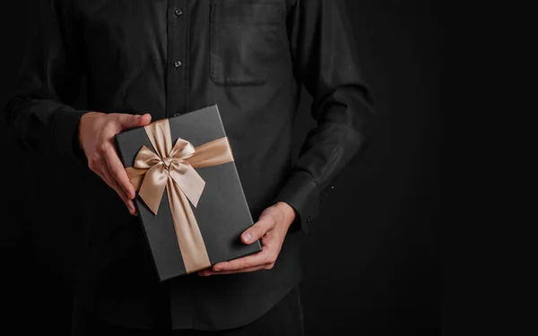 Tipo Con Una Camisa Negra Sostiene Regalo Con Una Cinta —  Fotos de Stock