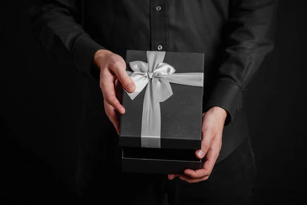 Ένας Τύπος Μαύρο Πουκάμισο Ανοίγει Ένα Δώρο Μια Ασημένια Κορδέλα — Φωτογραφία Αρχείου