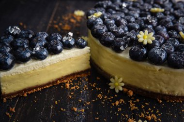 Bir dilim yabanmersinli cheesecake ve yanında büyük bir pasta. Yabanmersinli turta.
