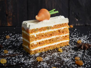 Siyah arka planda kremalı havuçlu kek ve havuç..