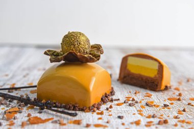 Çikolatayla süslenmiş karamelli şekerleme ve yenilebilir altınla kaplı bir top. Hafif ahşap arka planda tatlılık. Kesme şeker.