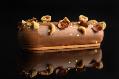 Siyah arka planda fındıklı, jöleli pasta..