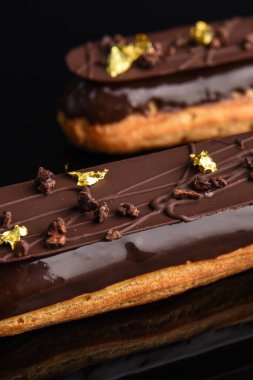 Siyah arka planda çikolata jöleli ekler..