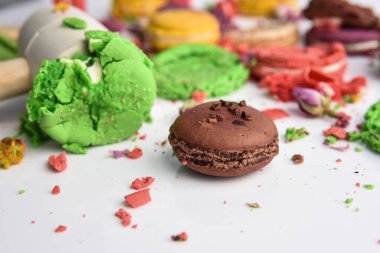 Beyaz bir arka planda farklı renklerde, çekiçle ezilmiş badem kurabiyesi..