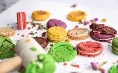 Beyaz bir arka planda farklı renklerde, çekiçle ezilmiş badem kurabiyesi..