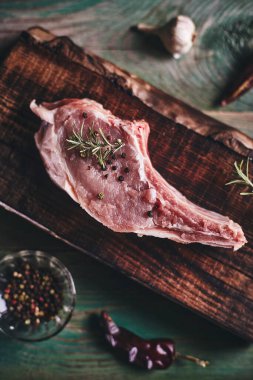 Tahta kesme tahtasına kemikli domuz bifteği. Çiğ et.