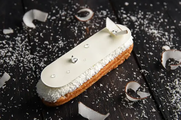 Éclair Vitrée Blanche Avec Chocolat Blanc Comestible Sur Fond Bois Photo De Stock