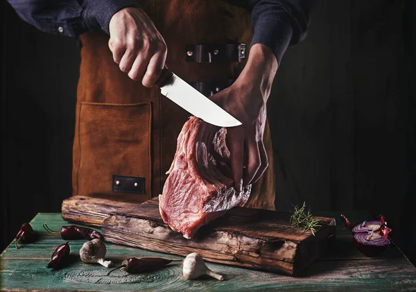 앞치마를 남자가 생고기를 있어요 정육점 주인은 돼지고기 갈비를 냅니다 위에서 스톡 사진