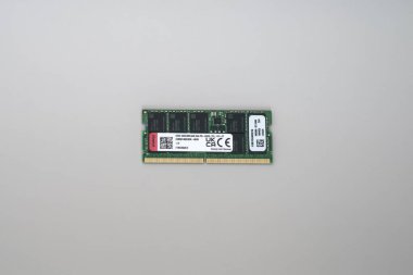 Beyaz etiketli yeşil DDR5 ECC RAM bellek yakın plan, altın lensler ve siyah çipler, sade beyaz yüzey izole.