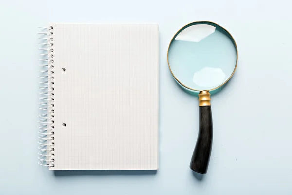 Vergrootglas en notebook — Stockfoto