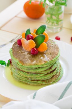 Yeşil ıspanak ile krep ve muz, narenciye, nane ve kızılcık dekore edilmiş