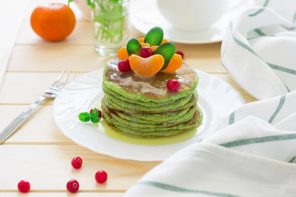 Panqueques verdes con espinacas y plátanos decorados con cítricos, menta y arándanos — Foto de Stock