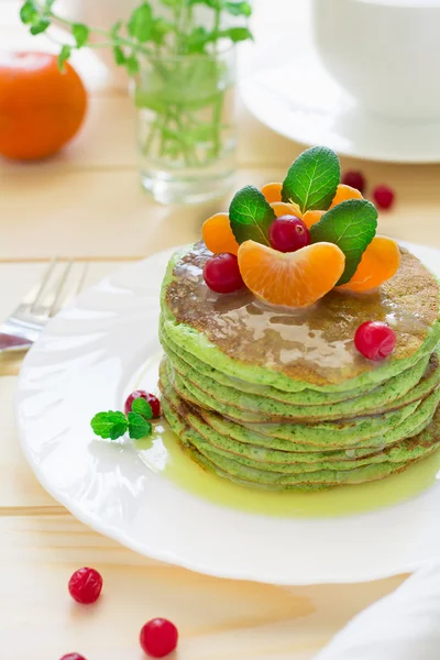 Panqueques verdes con espinacas y plátanos decorados con cítricos, menta y arándanos — Foto de Stock