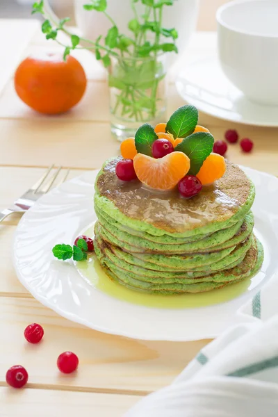 Panqueques verdes con espinacas y plátanos decorados con cítricos, menta y arándanos — Foto de Stock