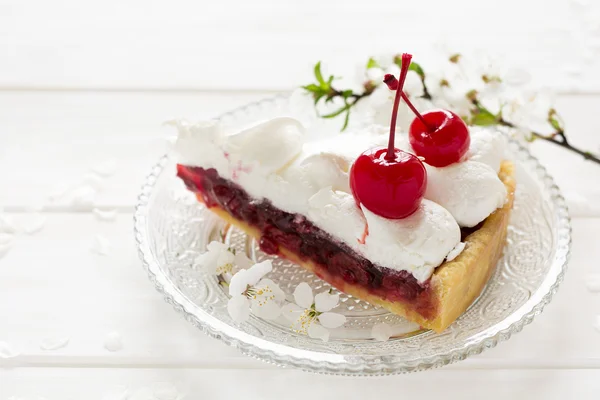 Slice of homemade pie with cherry and meringue decorated cherry blossom — Stock Photo, Image