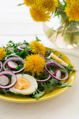 Sarı plaka üzerinde taze yeşil karahindiba salatası