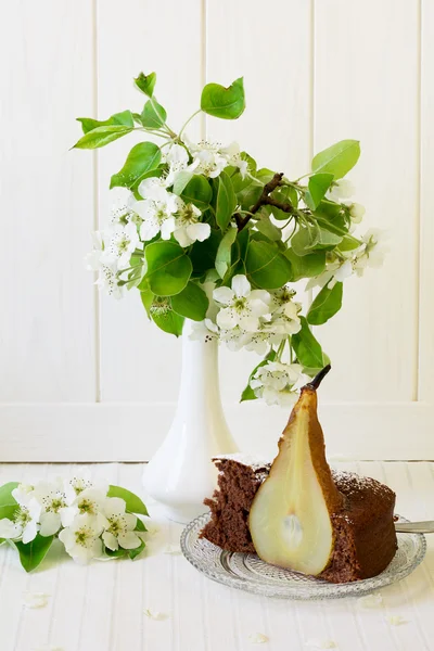 Piece of homemade chocolate cake with pears decorated pear blossom — Stock Photo, Image