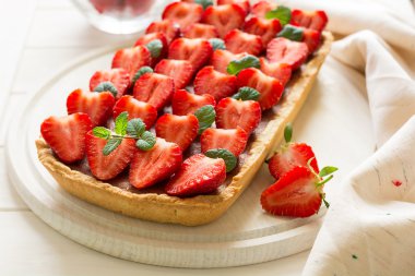 Çilek ve çilek lor ile ev yapımı tart nane yaprakları dekore edilmiştir.