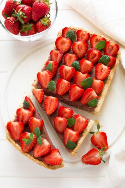 Çilek ve çilek lor ile ev yapımı tart nane yaprakları dekore edilmiştir.