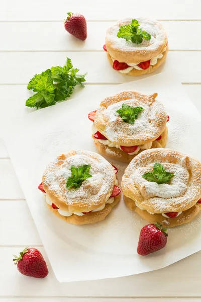 Anillos de eclair caseros con crema de requesón y fresas decoradas con hojas de menta — Foto de Stock