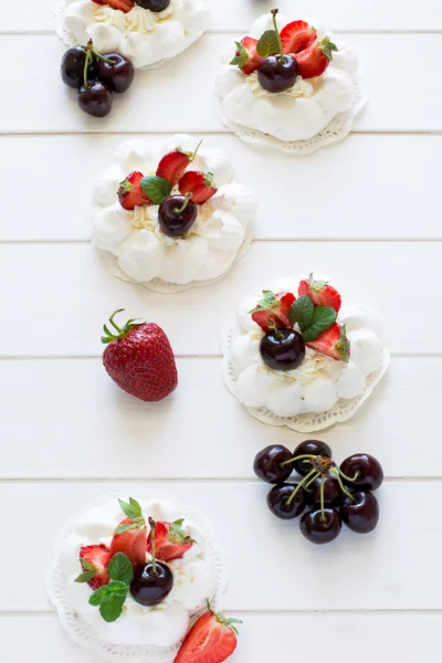 Torturi mici pavlova de casă cu cremă de mascarpone, căpșuni, cireșe și frunze proaspete de mentă — Fotografie, imagine de stoc