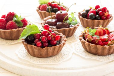 Çikolatalı Krema, taze çilek, ahududu, yaban mersini, kırmızı kuş üzümü ve kiraz çikolata tartlets, yakın çekim 