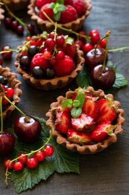 Çikolatalı Krema, taze çilek, ahududu, yaban mersini, kırmızı kuş üzümü ve kiraz çikolata tartlets, yakın çekim 