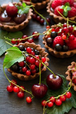 Çikolatalı Krema, taze çilek, ahududu, yaban mersini, kırmızı kuş üzümü ve kiraz çikolata tartlets, yakın çekim 