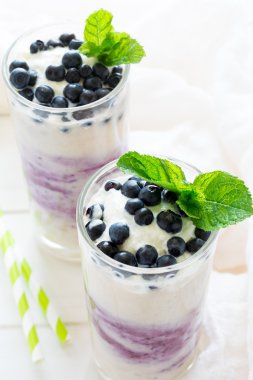 İki bardak taze yaban mersini dekore edilmiş smoothie çilek ve nane yaprakları ile. Seçici odak