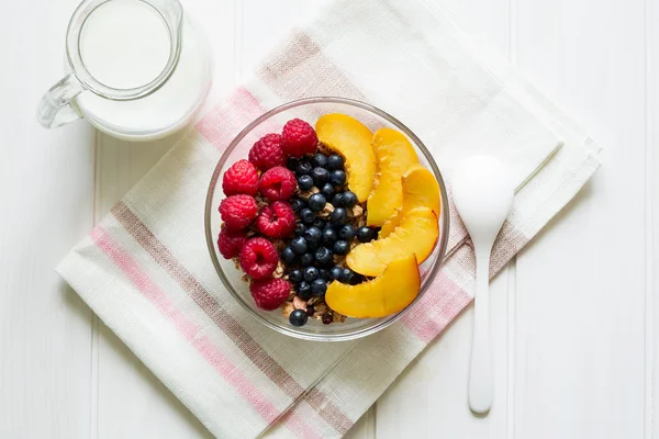 Café da manhã saudável: muesli com mel, leite e bagas frescas em uma tigela — Fotografia de Stock