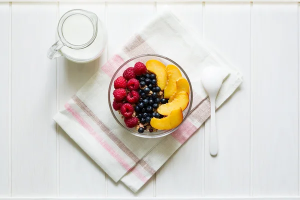 Café da manhã saudável: muesli com mel, leite e bagas frescas em uma tigela — Fotografia de Stock